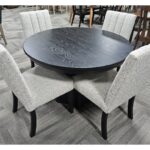 This clearance Brogan Table and Wittenburg Chairs set features a round top with four sleek, upholstered dining chairs.